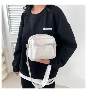 Close-up of iridescent crossbody bag showing metal texture and adjustable strap detail