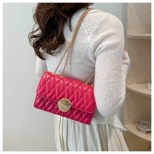 Détail du sac matelassé fuchsia avec couture en V et fermoir rotatif en métal doré