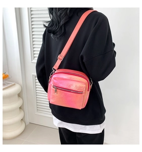 Detalle de bolso bandolera láser degradado con cremallera doble y correa ajustable