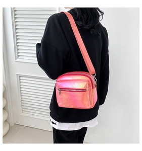 Vista trasera de una modelo con el bolso bandolera rosa láser y doble cremallera