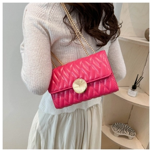 Détail du sac matelassé rose avec chaîne dorée et fermoir rotatif vintage à engrenages