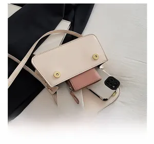 Internal storage view of off-white faux leather square bag showing phone and wallet capacity