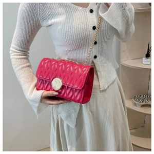 Détail du sac à chaîne rose matelassé avec fermoir doré en spirale et texture
