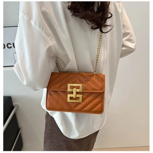 Quilted brown leather crossbody bag with V-pattern stitching and golden geometric clasp