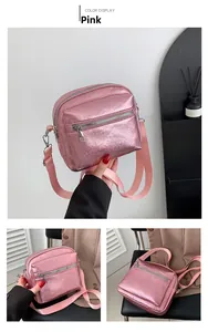 Detalle del bolso bandolera rosa metalizado con acabado perlado y cremalleras plateadas