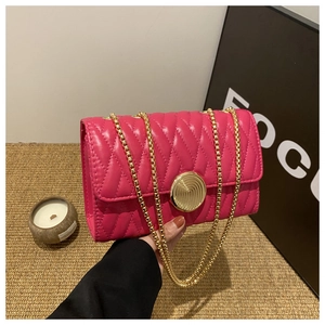 Détail du sac bandoulière matelassé rose fuchsia avec chaîne dorée et fermoir rond