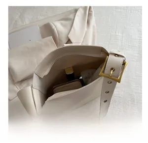 Interior view of beige PU crossbody bag showing large capacity for makeup and wallet