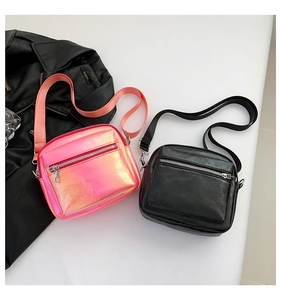 Detalle de bolsos bandolera en naranja metalizado y negro con correas de nailon ajustables