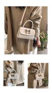 Detail of silver bow hardware and smooth cream leather texture on the mini handbag