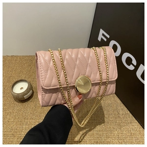 Détail du sac bandoulière rose avec matelassage ondulé et boucle en métal doré chic