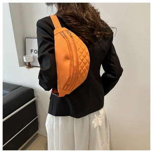 Detail view of the orange quilted nylon crossbody bag with adjustable strap and buckle