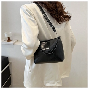Detail view of black PU leather shoulder bag with fashion patch and chunky chain strap