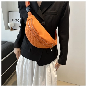 Detail of orange quilted nylon belt bag featuring double zippers and adjustable strap