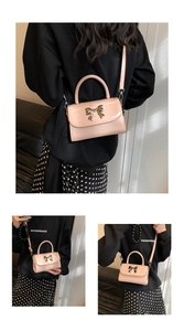 Detail of pink patent leather mini bag featuring a gold bow clasp and round handle