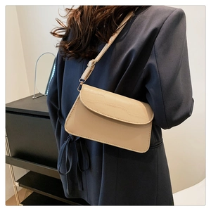 Chic beige crossbody bag with faux crocodile texture shown on female model outfit