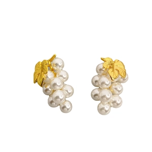 Fashionable grape-shaped pearl stud earrings with gold leaves on a white background