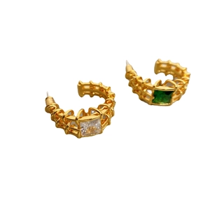 Golden C-shaped earrings with hollow mesh pattern and asymmetrical square zircon stones
