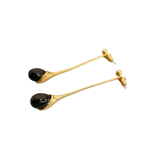 Elegant gold drop earrings featuring black teardrop onyx stones and long metal pendants