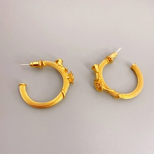 Golden C-shaped brushed metal earrings featuring detailed 3D rose relief accents