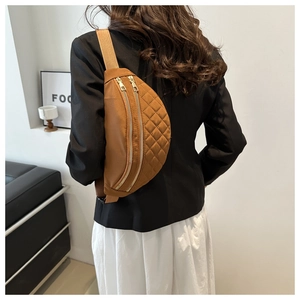 Detail of brown quilted nylon crescent bag with gold zippers and adjustable strap