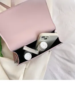 Macro shot showing internal storage space for phone and makeup in the pink satchel bag