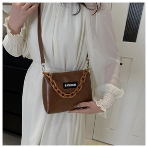 Brown faux leather shoulder bag with acrylic chain strap and fashion label detail