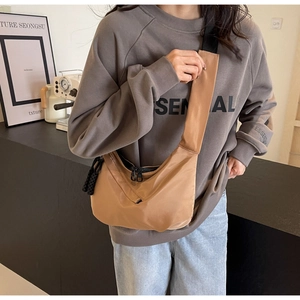 Detailed side view of the khaki crescent nylon bag showing the adjustable canvas strap