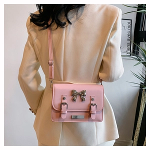 Detailed back view of pink leather crossbody bag with silver bow buckle on model