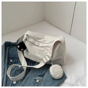 Détail du sac bandoulière blanc cassé avec étiquette fashion et petit porte-monnaie