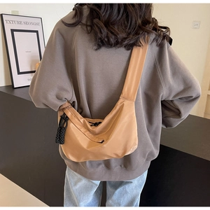 Große khaki Nylon-Halbmondtasche mit breitem Schultergurt in der Rückansicht am Model
