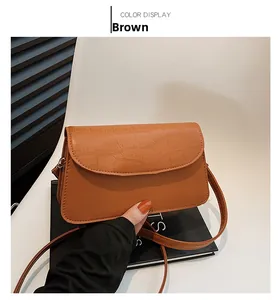 Close-up of brown PU leather crossbody bag featuring a textured crocodile embossed pattern
