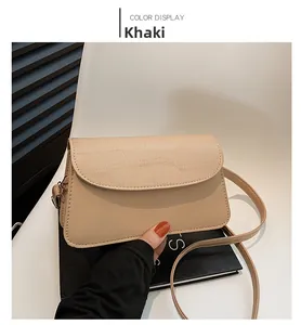 Detail of khaki square crossbody bag with faux crocodile texture on the flap