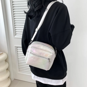 Iridescent white crossbody bag with adjustable strap shown on model in white studio