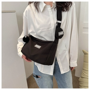 Détail du sac fourre-tout noir en nylon avec mini-pochette et étiquette tissée fashion