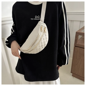 Close-up of quilted white nylon chest bag with golden double zippers and textile strap