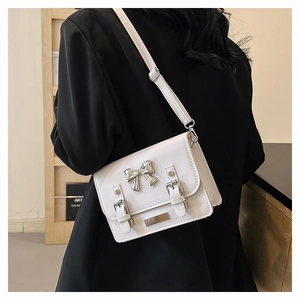 Detail of white PU leather crossbody bag with silver bow and adjustable strap