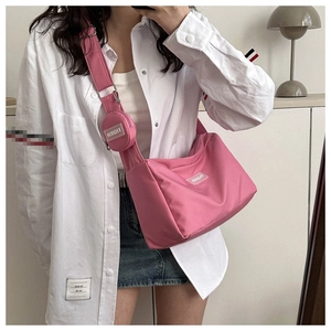 Sac fourre-tout en nylon rose avec mini pochette ronde porté avec une tenue décontractée