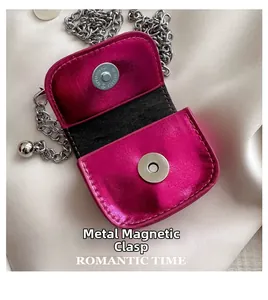Macro shot of hot pink metallic mini bag with silver chain and hardware snap button