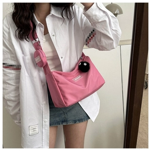 Détail d'un ensemble de sac bandoulière en nylon rose avec un petit porte-monnaie rond