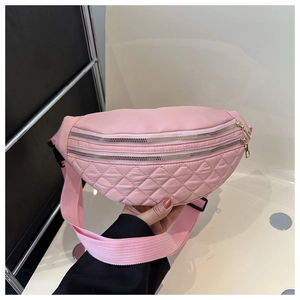 Detailed close-up of pink quilted nylon fanny pack with double gold zippers and woven strap