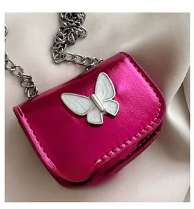 Close-up of fuchsia metallic mini lipstick bag with white butterfly and silver chain