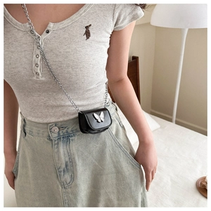 Close-up of mini black leather crossbody bag with silver butterfly and chain strap