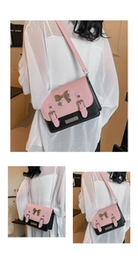 Detail of pink and black contrast satchel bag with metallic bow and buckle accents