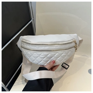 Macro detail of white quilted nylon fabric and dual golden zippers on the chest bag