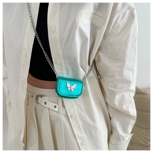 Close-up of mini lime green butterfly crossbody bag with silver chain on model