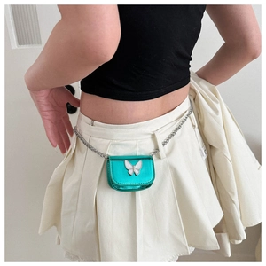 Metallic green mini chain waist bag with white enamel butterfly worn by model
