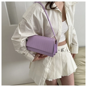 Macro shot of purple woven leather texture and metal buckle on minimalist shoulder bag