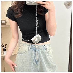 Silver mini crossbody bag with butterfly print and thin metal chain worn by a model