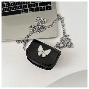 Detailed shot of mini black leather bag with silver butterfly charm and chain strap