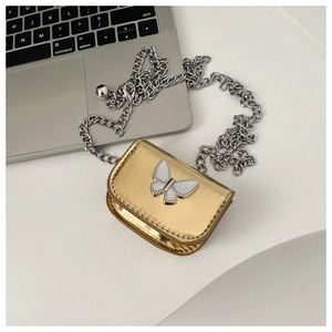 Detailed shot of golden mini crossbody bag with butterfly clasp and silver chain strap